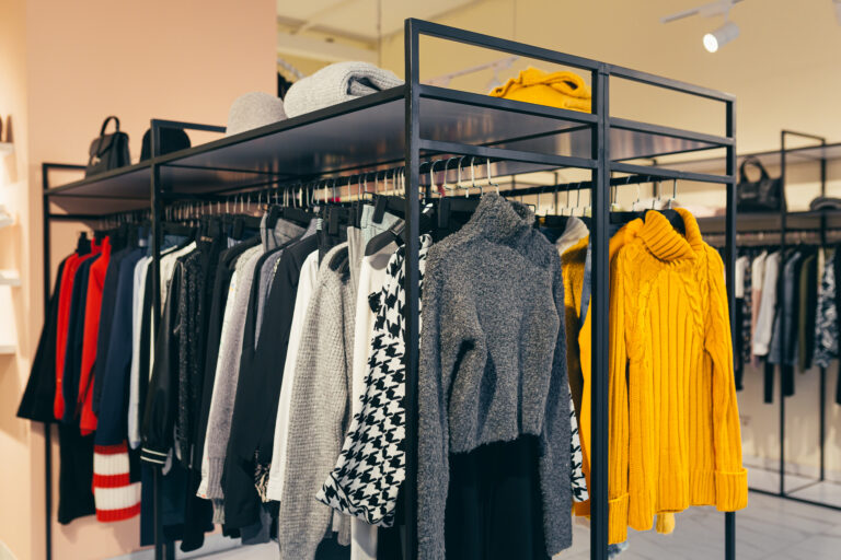 Fashion store. A number of different colorful women's clothes hanging on a shelf in the show room